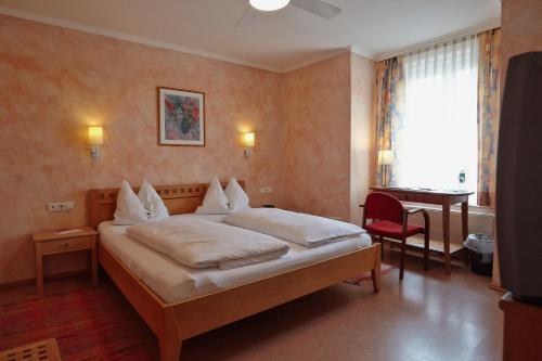 a hotel room with a bed and a desk at Hotel Restaurant Itzlinger Hof in Salzburg