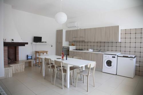 a kitchen with a table and chairs and a washing machine at Casa Solento in Maruggio