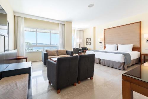 a hotel room with a bed and a living room at Eurostars Isla de La Toja in Isla de la Toja