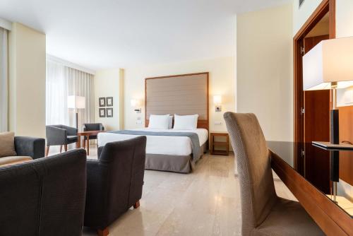 a hotel room with a bed and some chairs at Eurostars Isla de La Toja in Isla de la Toja