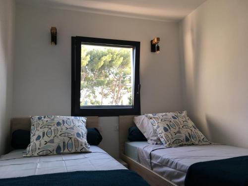 a small room with two beds and a window at Cassis Ma Vie Là in Cassis