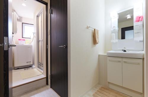 a bathroom with a sink and a mirror at Nishikamata ColorBee House in Tokyo