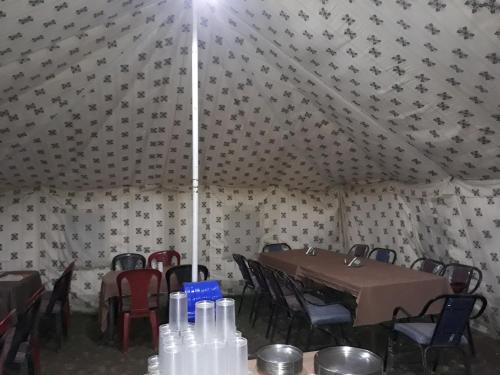 a dining room with a table and chairs in a tent at Himalayan Routes Camp Sarchu in Sir Bhum Chun