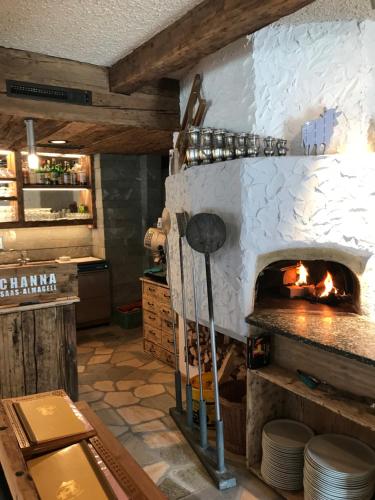 a kitchen with a stone fireplace in a restaurant at Apart-hotel Channa in Saas-Almagell