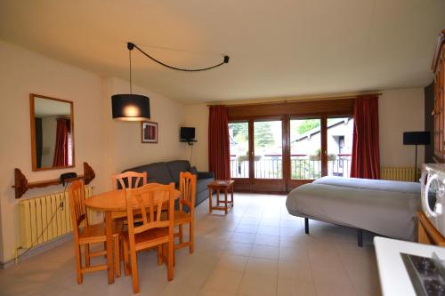 阿林薩爾的住宿－Apartamentos Turisticos Poblado，客厅配有桌子、床和沙发