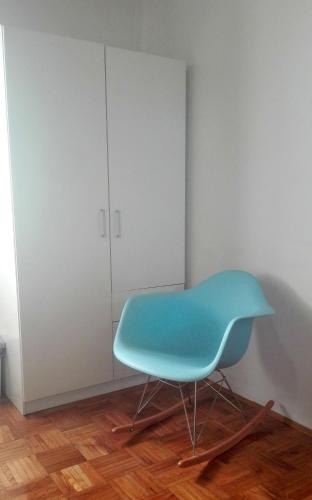 a blue chair in a room with a cabinet at Voyage in Varaždin