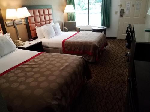 a hotel room with two beds and a window at Ramada by Wyndham Temple Terrace/Tampa North in Tampa
