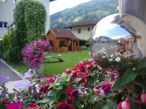 a person taking a picture in a mirror in a garden at Haus Schnepfleitner in Dorfgastein