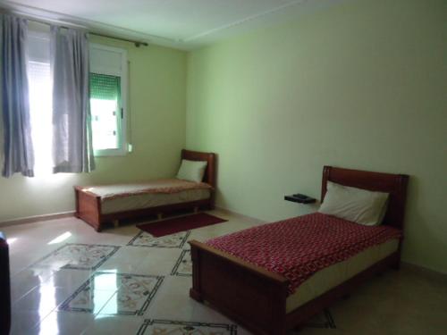 a living room with two beds and a window at Hotel Azul Palace in Sidi Yahia el Gharb