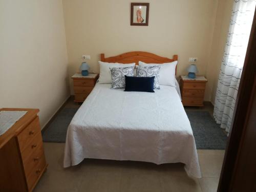 a bedroom with a large white bed with pillows at Apartamentos Colmado in Sanxenxo