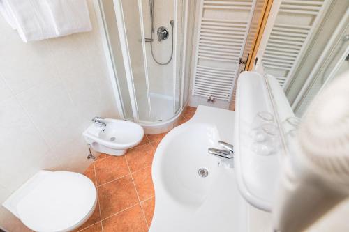 a bathroom with a sink and a shower and a toilet at Garni Rives in Ortisei