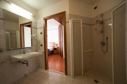 a bathroom with a sink and a shower and a mirror at Albergo La Lanterna in Sarteano