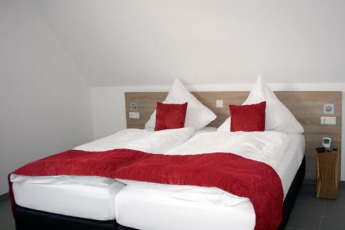 ビューズムにあるFerienwohnung dat witte hus 2のベッドルーム1室(ベッド2台、赤と白の枕付)