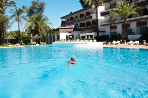 una persona in acqua in piscina di Hotel Jerez & Spa a Jerez de la Frontera