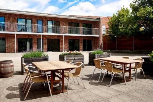 two tables and chairs in front of a brick building at Hotel Phønix in Holstebro