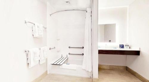 a white bathroom with a shower and a sink at Holiday Inn Express & Suites - Chalmette - New Orleans S by IHG in Chalmette