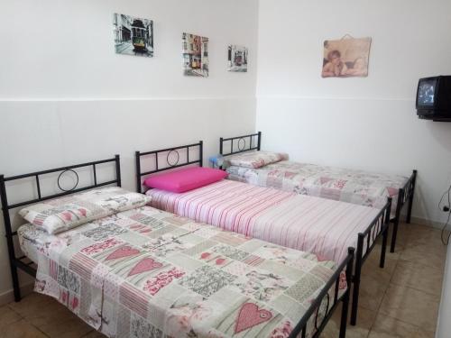 two beds in a room with white walls at Villa Punta Grossa 1 in Torre Lapillo