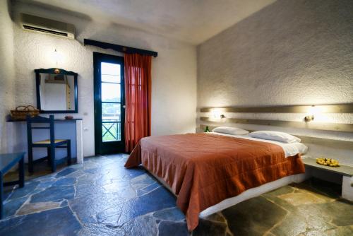 a bedroom with a large bed and a window at Vagia Beach Apartments, Aegina Island in Vaia