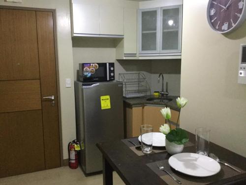 uma cozinha com um frigorífico e uma mesa com pratos em Palm Tree Villas 2 em Manilla
