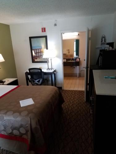 a hotel room with a bed and a desk at Ramada by Wyndham Temple Terrace/Tampa North in Tampa