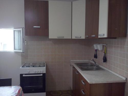a small kitchen with a stove and a sink at Villa Punta Grossa 1 in Torre Lapillo