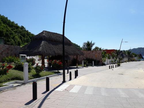 a street with a straw hut and a street light at La Quinta Gran Bahía, Cuastecomates - Todo Incluido in Cuastecomate