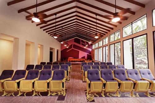 an empty room with blue chairs and large windows at Hotel Jungle Lodge Tikal in Tikal