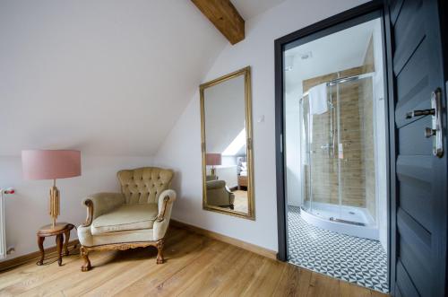 a mirror in a room with a chair and a mirror at Apartamenty Mieszczańskie u Gołębiewskich in Toruń