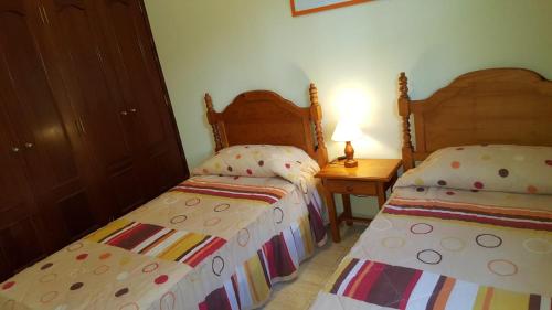 Un dormitorio con dos camas y una mesa con lámpara. en Finca Contero, en Valle Gran Rey