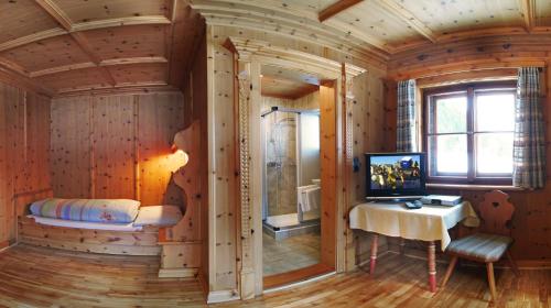 a wooden room with a desk and a television in it at Landgut Gamsleiten in Bad Gastein
