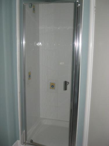y baño con ducha y puerta de cristal. en Eastbourne Reymar, en Eastbourne