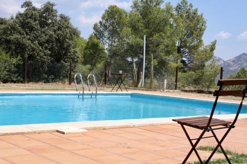 a chair sitting next to a swimming pool at Mas Del Cigarrer Allotjament Rural in Horta de San Joan