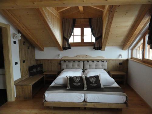 um quarto com uma cama grande num quarto com tectos em madeira em B&B Mas di Zonadi em Rabbi