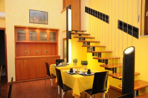ein Esszimmer mit einem Tisch und einer Wendeltreppe in der Unterkunft Affittacamere Conte Di Cavour in Noto