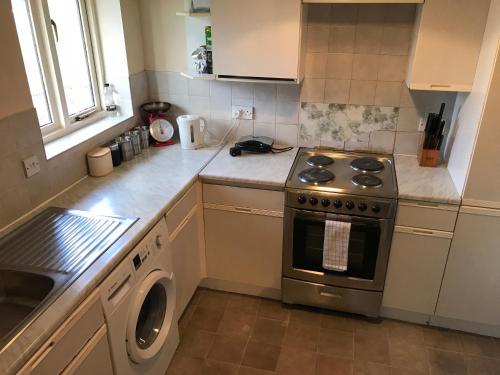 a kitchen with a stove and a washing machine at Flat 9a Badby Close in Manchester