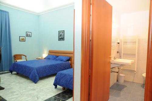 1 dormitorio con 1 cama y baño con lavamanos en Affittacamere Conte Di Cavour, en Noto