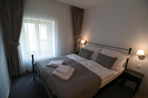 a bedroom with a bed with two towels on it at Wise Owl Apartments in Banská Štiavnica