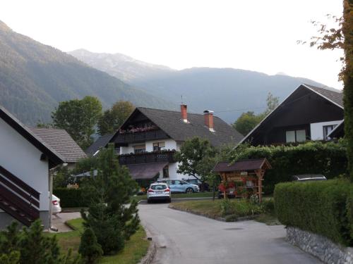 a house with a car parked in a driveway at Snežak (Snowman) 2 in Bohinj