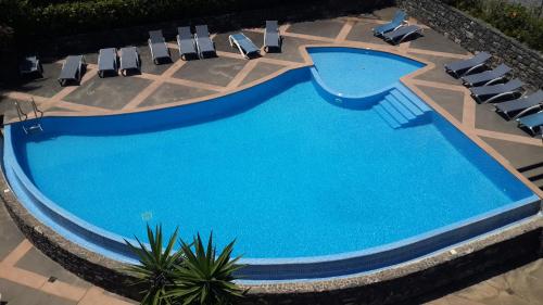 an overhead view of a swimming pool with lounge chairs at Jasmineiro - Palms Palace Apartment in Funchal