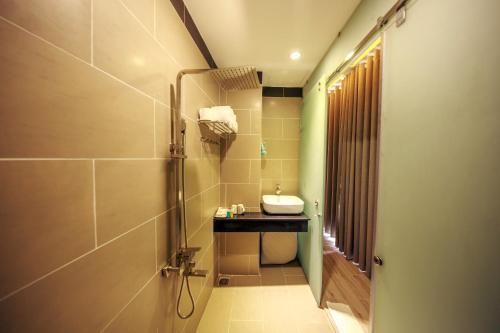 a bathroom with a sink and a shower at VARIA Hotel Phu Quoc in Phu Quoc