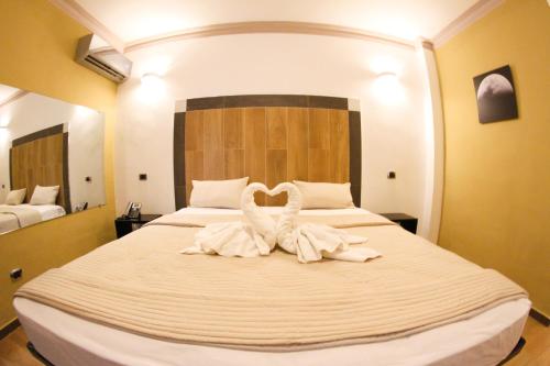 dos cisnes sentados en una cama en una habitación de hotel en FrioHot Boca Chica en Boca Chica