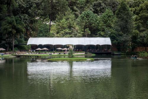 a lake with a building in the middle of it at Rodavento Boutique Hotel & Spa in Valle de Bravo