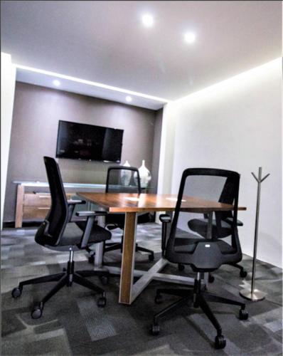 an office with a wooden table and two chairs at NEhotel Nueva Estancia in León