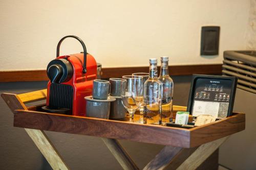 a wooden table with wine glasses and a suitcase at Rodavento Boutique Hotel & Spa in Valle de Bravo