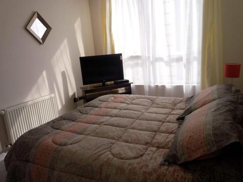 1 dormitorio con 1 cama y TV de pantalla plana en Departamento 706 5 Poniente, en Viña del Mar