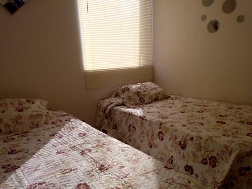 2 camas en una habitación pequeña con ventana en Departamento 706 5 Poniente, en Viña del Mar