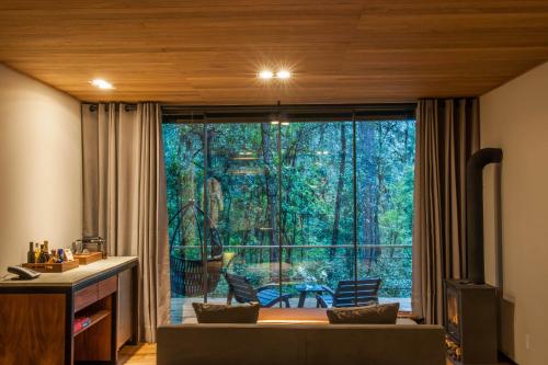 a living room with a large window and a couch at Rodavento Boutique Hotel & Spa in Valle de Bravo
