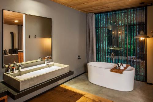 ein Badezimmer mit einer großen Badewanne und einem großen Fenster in der Unterkunft Rodavento Boutique Hotel & Spa in Valle de Bravo