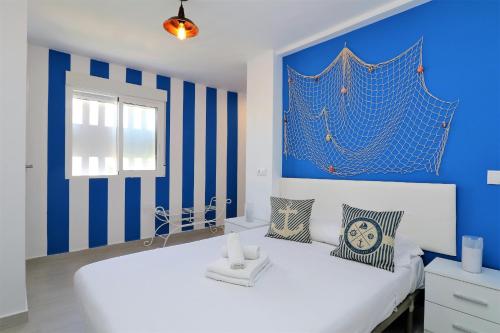 a blue and white bedroom with a large white bed at Bacana 9-4 in Benidorm