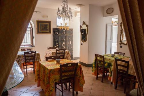 una sala da pranzo con tavoli, sedie e lampadario a braccio di Villa Donna Fausta P. ad Agerola